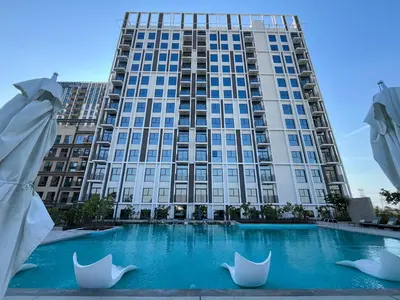 a large building with a swimming pool in front of it at Modern & Stylish Stay in 1BR Socio Dubai Hills in Dubai