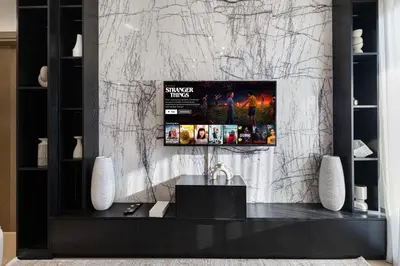 a living room with a tv on a marble wall at Deluxe Binghatti Suites by Hostiva - Burj View in Dubai