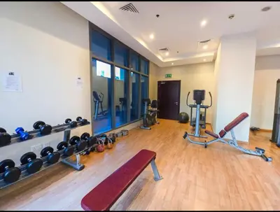 a gym with dumbbells and a bench in a room at Entire Apartment in Dubai Marina in Dubai