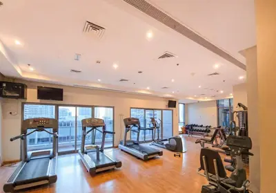 a gym with several treadmills and elliptical machines at Entire Apartment in Dubai Marina in Dubai