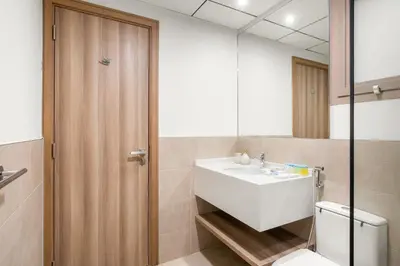 a bathroom with a sink and a toilet and a mirror at Cozy 2BR with Canal View & Partial Burj View in Dubai