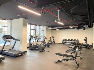 a gym with several treadmills and exercise bikes at Cozy 2BR with Canal View & Partial Burj View in Dubai