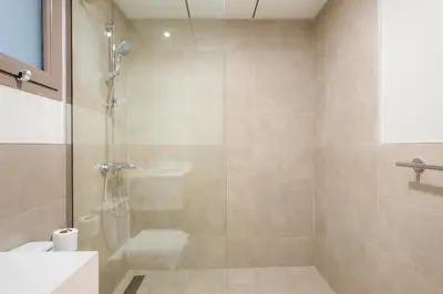 a bathroom with a shower with a toilet and a sink at Cozy 2BR with Canal View & Partial Burj View in Dubai