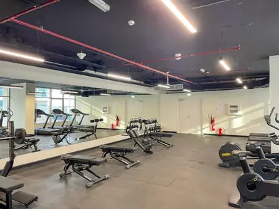 a gym with several rows of treadmills and machines at Cozy 2BR with Canal View & Partial Burj View in Dubai