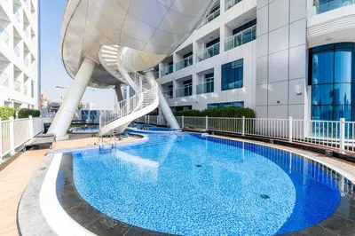 a large swimming pool with a spiral staircase next to a building at Limited Time l Private Pool I Elegance l Prime Location in Dubai