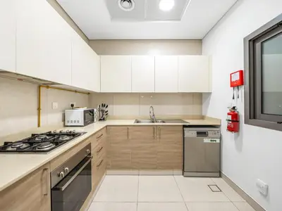 a kitchen with white cabinets and a stove at Stylish 1BR Near Burj Khalifa with Rooftop Pool, City Views, Free Parking in Dubai