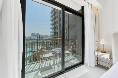 a room with a balcony with a view of the city at Bright Studio Retreat in Floarea Residence Arjan in Dubai