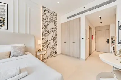 a white bedroom with a white bed and a desk at Bright Studio Retreat in Floarea Residence Arjan in Dubai