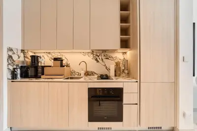 a kitchen with white cabinets and an oven at Bright Studio Retreat in Floarea Residence Arjan in Dubai