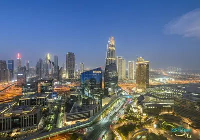 a night view of a city with a lot of buildings at FULL Burj Khalifa View Luxe 3BR in Address Opera in Dubai