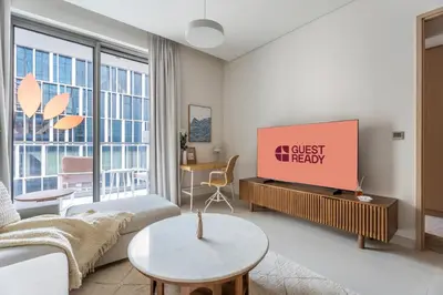 a living room with a couch and a tv at GuestReady - 1BR Near Dubai Mall | Downtown Stay in Dubai