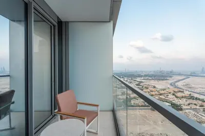 a chair on a balcony with a view of a city at GuestReady - 1BR Near Dubai Mall | Downtown Stay in Dubai