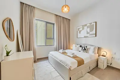 a bedroom with a large bed and a window at Your Dubai Hills Retreat 1BR in Park Heights 2 in Dubai