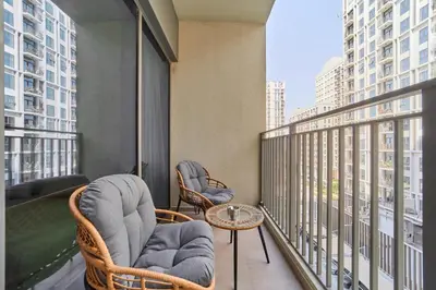 a balcony with two chairs and a table on a building at Your Dubai Hills Retreat 1BR in Park Heights 2 in Dubai