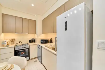 a kitchen with a stove and a refrigerator at Your Dubai Hills Retreat 1BR in Park Heights 2 in Dubai