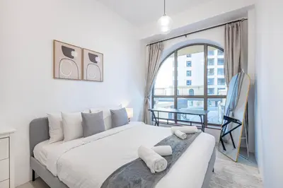 a bedroom with a bed and a large window at Bahar 1, JBR - 2 Bedroom Apartment - Allsopp & Allsopp in Dubai