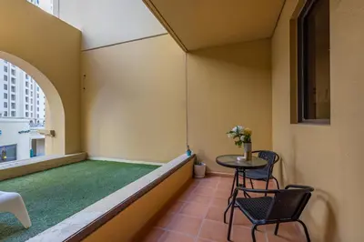 a small room with a green floor and a table and chairs at Bahar 1, JBR - 2 Bedroom Apartment - Allsopp & Allsopp in Dubai