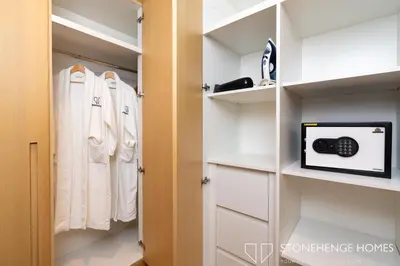 a walk in closet with white clothes at Cozy 1BR in Belgravia , JVC, Pool View, 20 Min from Downtown Dubai in Dubai