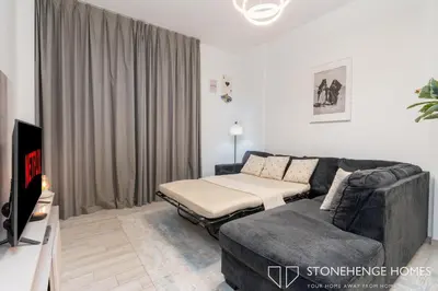 a living room with a bed and a couch at Cozy 1BR in Belgravia , JVC, Pool View, 20 Min from Downtown Dubai in Dubai