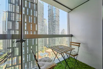 a balcony with a table and chairs and a view of a city at Twisting Tower Stay a Chic 2BR in Cayan Tower in Dubai
