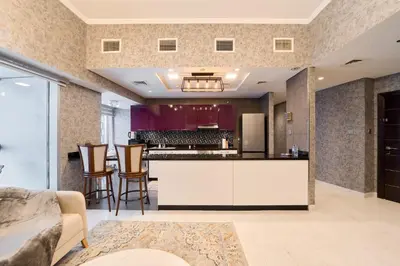 a living room with a kitchen and a bar at Twisting Tower Stay a Chic 2BR in Cayan Tower in Dubai