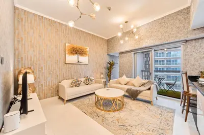 a living room with a couch and a table at Twisting Tower Stay a Chic 2BR in Cayan Tower in Dubai