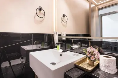 a bathroom with a white sink and a black counter at HAVN - Spacious One Bedroom in Binghatti Creek in Dubai