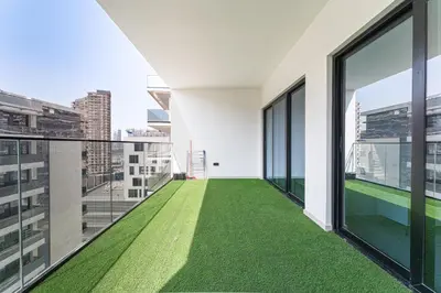 a balcony with green flooring in a building at HAVN - Spacious One Bedroom in Binghatti Creek in Dubai