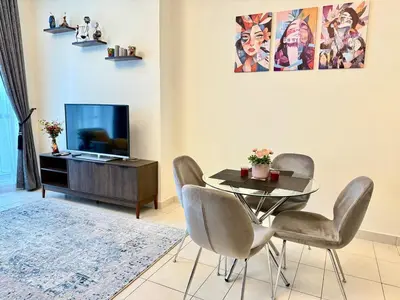 a dining room with a table and chairs and a tv at Cozy apartment in Dubai Marina - Torch Tower in Dubai