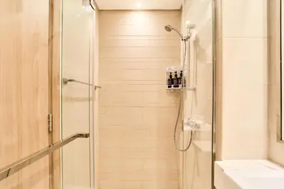 a bathroom with a shower with a glass door at Bright & Cozy Studio in Vibrant Azizi Riviera in Dubai