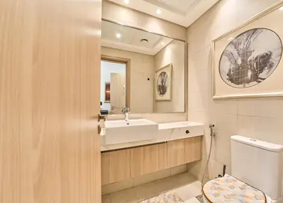 a bathroom with a sink and a toilet and a mirror at Bright & Cozy Studio in Vibrant Azizi Riviera in Dubai