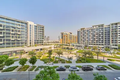 a parking lot in a city with tall buildings at Bright & Cozy Studio in Vibrant Azizi Riviera in Dubai