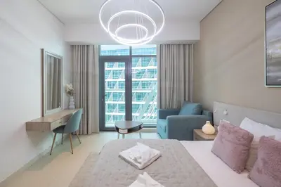 a bedroom with a large bed and a blue couch at Elegant One-Bedroom Sea View Retreat on Palm West in Dubai
