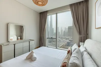 a bedroom with a bed and a large window at HAVN - 2 Bed Burj Khalifa View, Access Dubai Mall in Dubai