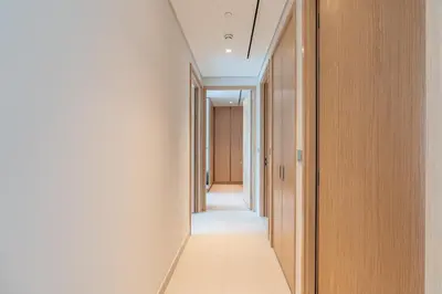 a hallway with white walls and wooden doors at HAVN - 2 Bed Burj Khalifa View, Access Dubai Mall in Dubai