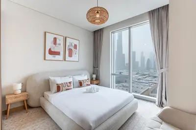 a bedroom with a bed and a large window at HAVN - 2 Bed Burj Khalifa View, Access Dubai Mall in Dubai