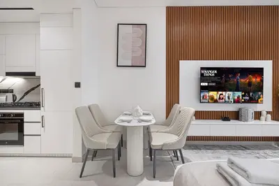 a white dining room with a table and chairs at Binghatti Trillionaire! 2 Double Beds! Private Jacuzzi, Prime Location! in Dubai