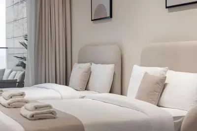 two beds in a hotel room with towels on them at Binghatti Trillionaire! 2 Double Beds! Private Jacuzzi, Prime Location! in Dubai