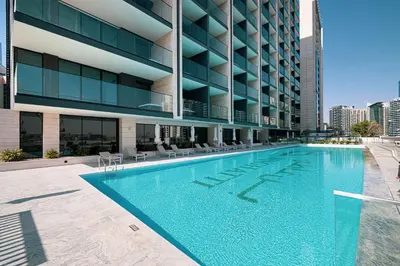 a swimming pool in front of a building at Binghatti Trillionaire! 2 Double Beds! Private Jacuzzi, Prime Location! in Dubai