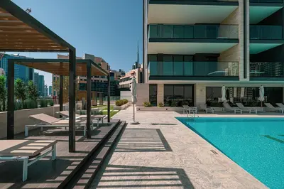 a building with a swimming pool next to a building at Binghatti Trillionaire! 2 Double Beds! Private Jacuzzi, Prime Location! in Dubai
