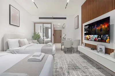a white bedroom with two beds and a flat screen tv at Binghatti Trillionaire! 2 Double Beds! Private Jacuzzi, Prime Location! in Dubai