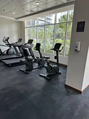 a gym with rows of exercise bikes in a room with windows at Fabulous 1 bed apartment within walking distance to Dubai mail and Burj Khalifa in Dubai