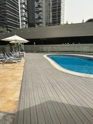 a large swimming pool with chairs and an umbrella at Fabulous 1 bed apartment within walking distance to Dubai mail and Burj Khalifa in Dubai
