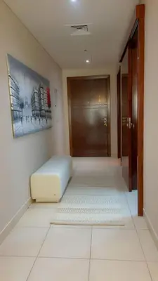 a living room with a white couch and a door at Cozy private master bedroom for solo female in shared home in Dubai