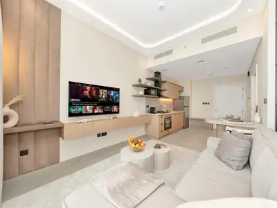 a living room with a white couch and a tv at Stylish 1-Bedroom in Collective 2 - Dubai Hills in Dubai