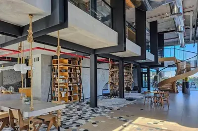 a loft with a staircase and tables and chairs at Stylish 1-Bedroom in Collective 2 - Dubai Hills in Dubai