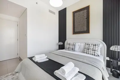 a bedroom with a large bed with towels on it at Burj Khalifa View From The Infinity Pool 2BR at Downtown Dubai in Dubai