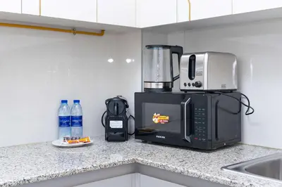a kitchen counter with a coffee maker and a microwave at PVH - Canal Frontage 1BR - Millennium Binghatti in Dubai