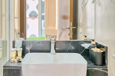 a bathroom with a white sink and a mirror at PVH - Canal Frontage 1BR - Millennium Binghatti in Dubai