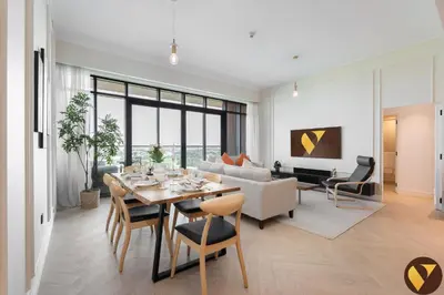 a living room with a table and a couch at Vogue Emirates Hills, Vida The Hills Residence near Marina and JBR, Three Bedroom Apartment with Balcony and Golf Club View, Access to all Amenities in Dubai